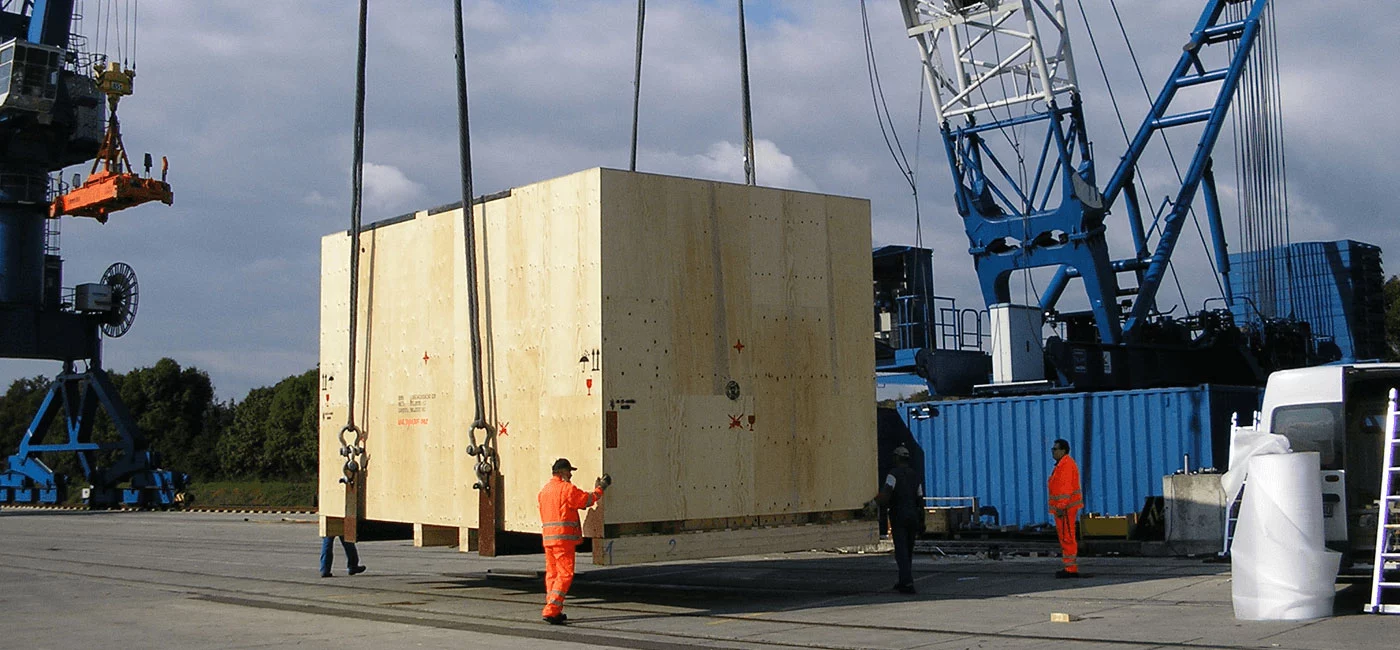 Schwere Ladung in Holzverpackung wird auf ein Schiff transportiert