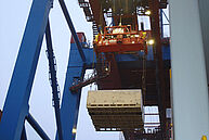 Enormous loading crane with a wooden box at the port of Hamburg